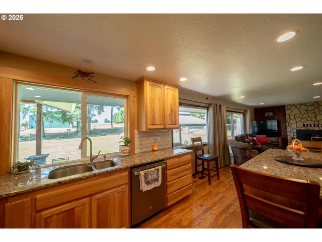 a kitchen with stainless steel appliances granite countertop sink stove and wooden cabinets