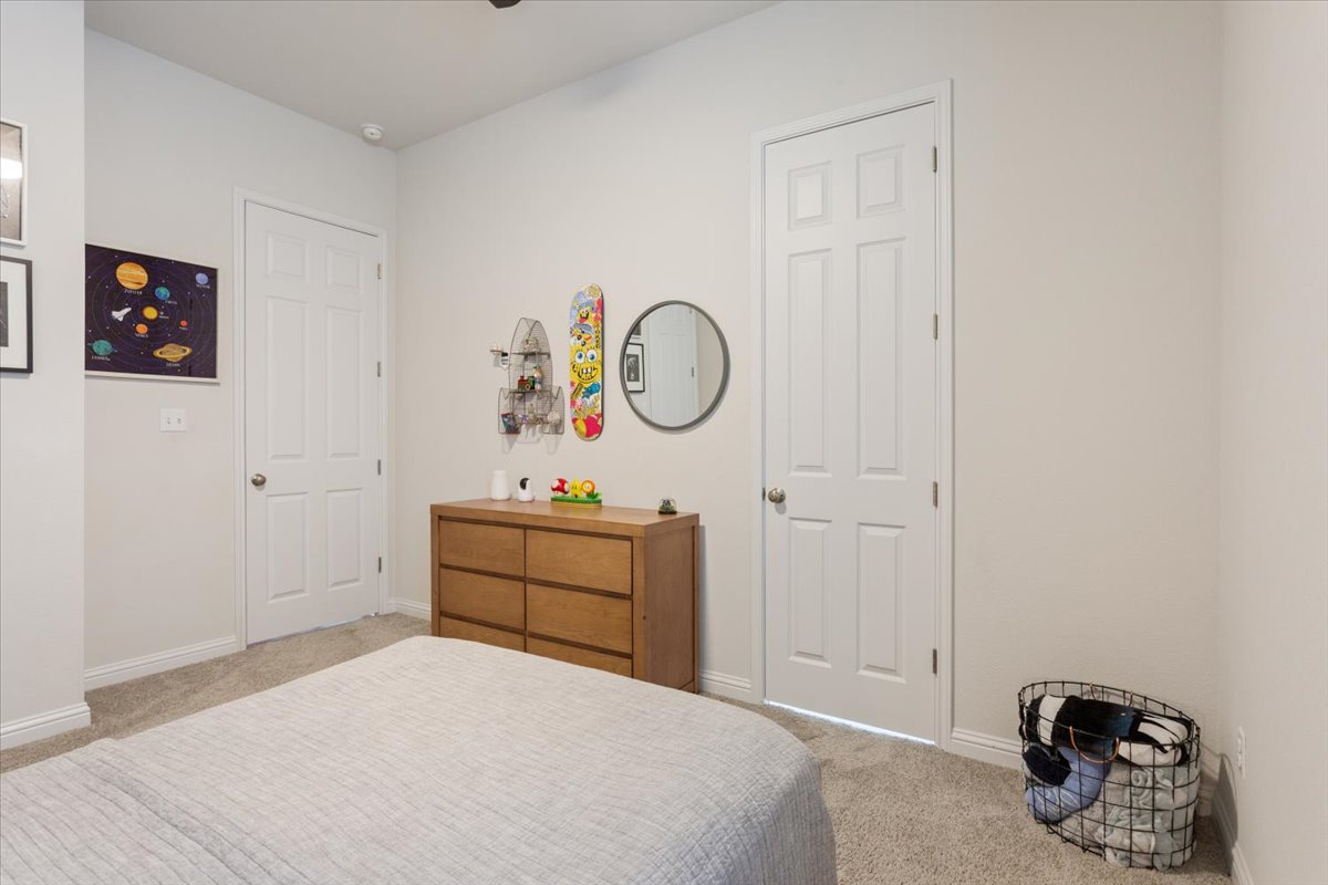 424 Millard Street Georgetown, TX 78628 - Photo 23 of 37 Comfortable bedroom featuring soft carpet and two paneled doors for privacy and convenience.