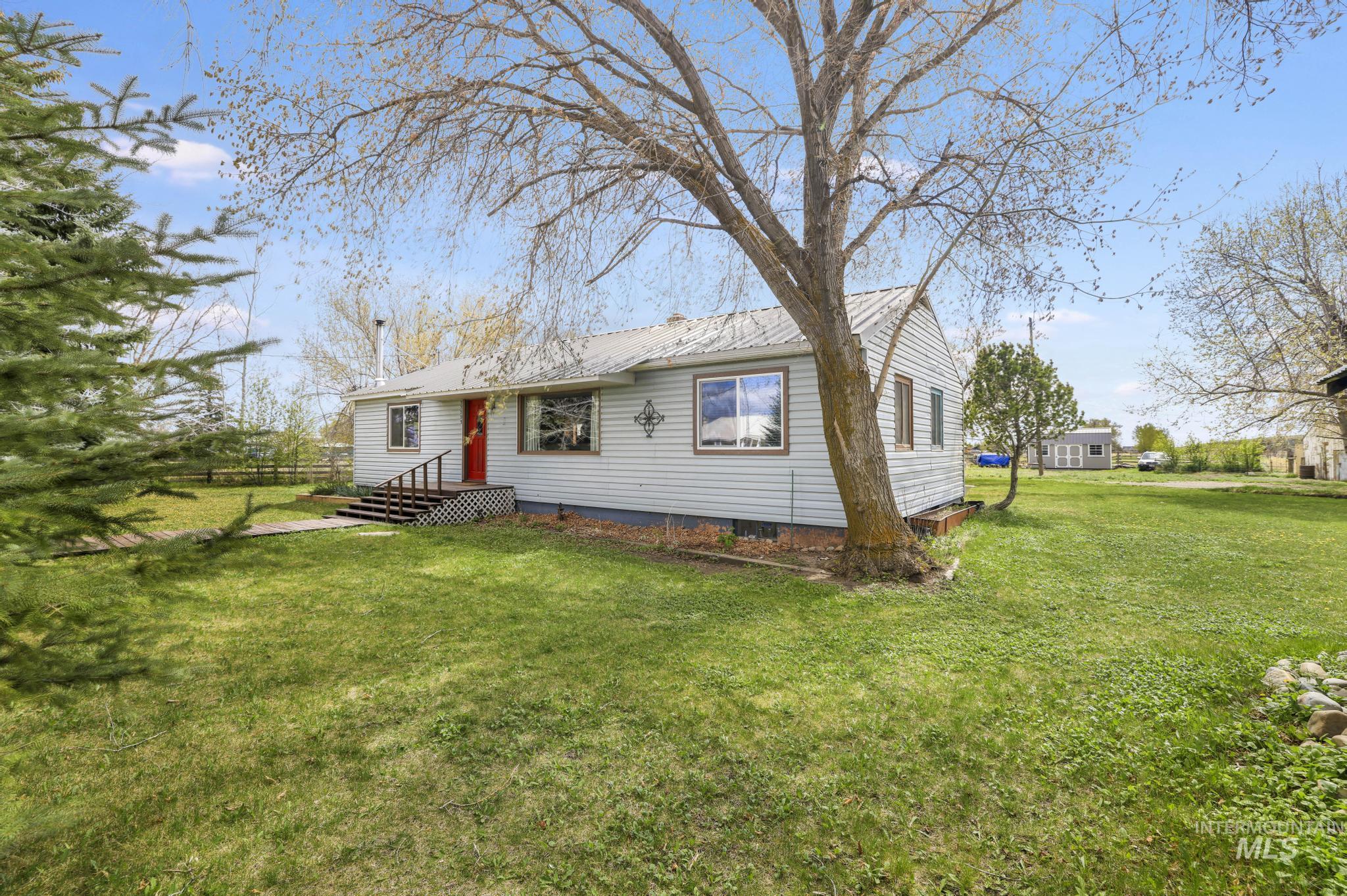 19591 Queen Crown Road Carey, ID 83320 - Photo 29 of 37 Single-story residence featuring light-colored horizontal siding and a red entry door