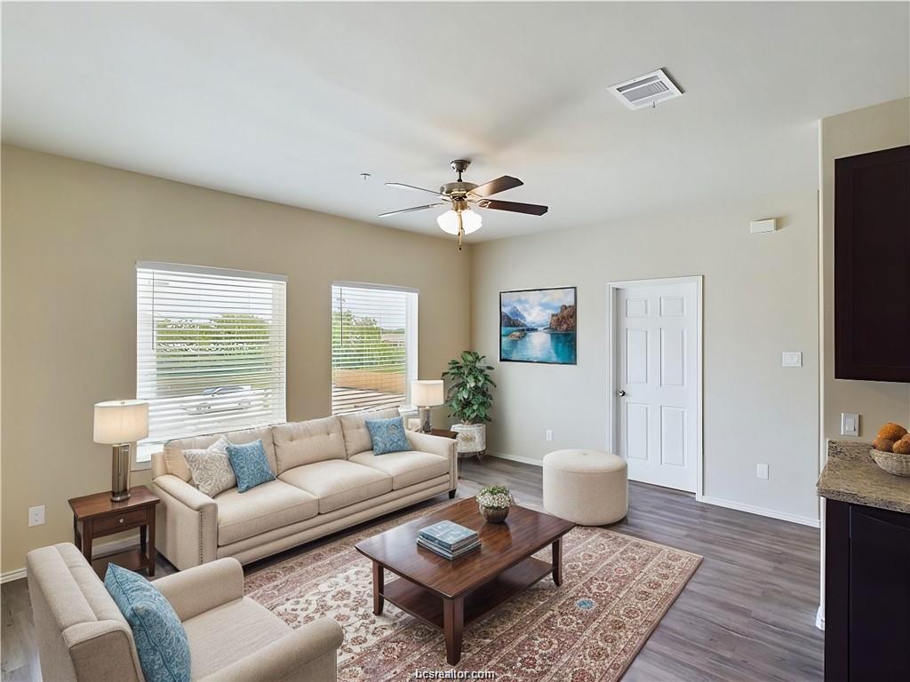 2910 Town Square Avenue, Unit 2604 Bryan, TX 77802 - Photo 2 of 8 a living room with furniture a rug and a flat screen tv
