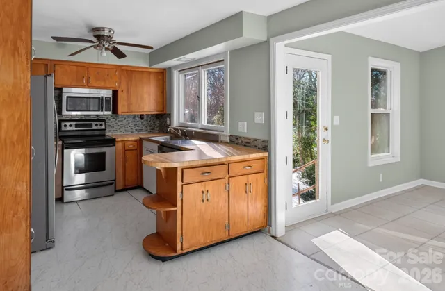 a kitchen with stainless steel appliances granite countertop a stove a sink and a refrigerator