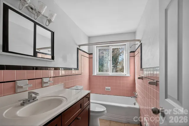 a bathroom with a sink a toilet a window and shower