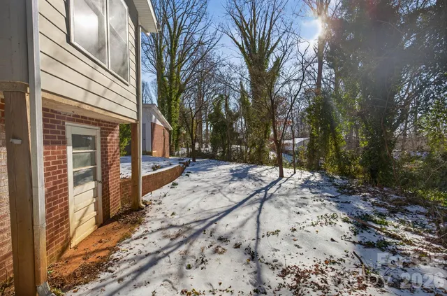a view of a backyard with snow on the road