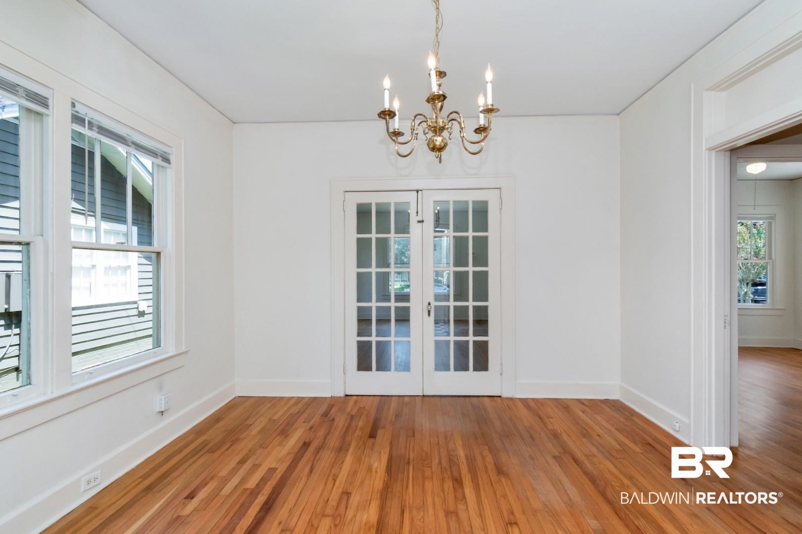 112 South Fulton Street Mobile, AL 36606 - Photo 13 of 35 Unfurnished dining area featuring plenty of natural light, a notable chandelier, french doors, and hardwood / wood-style flooring