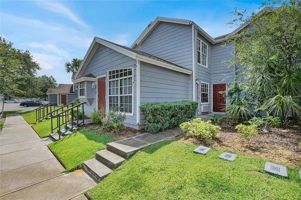 a view of a house with backyard and sitting area