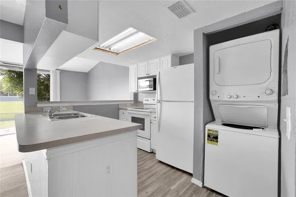 a kitchen that has a sink a stove and a refrigerator