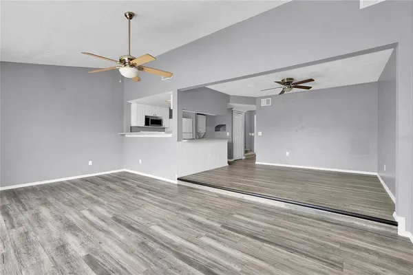 a view of a kitchen with wooden floor and a ceiling fan