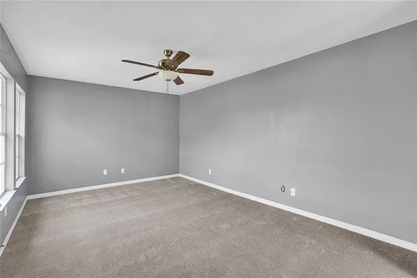 an empty room with a window and a fan