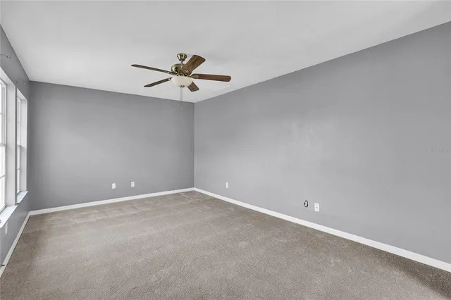 an empty room with a window and a fan