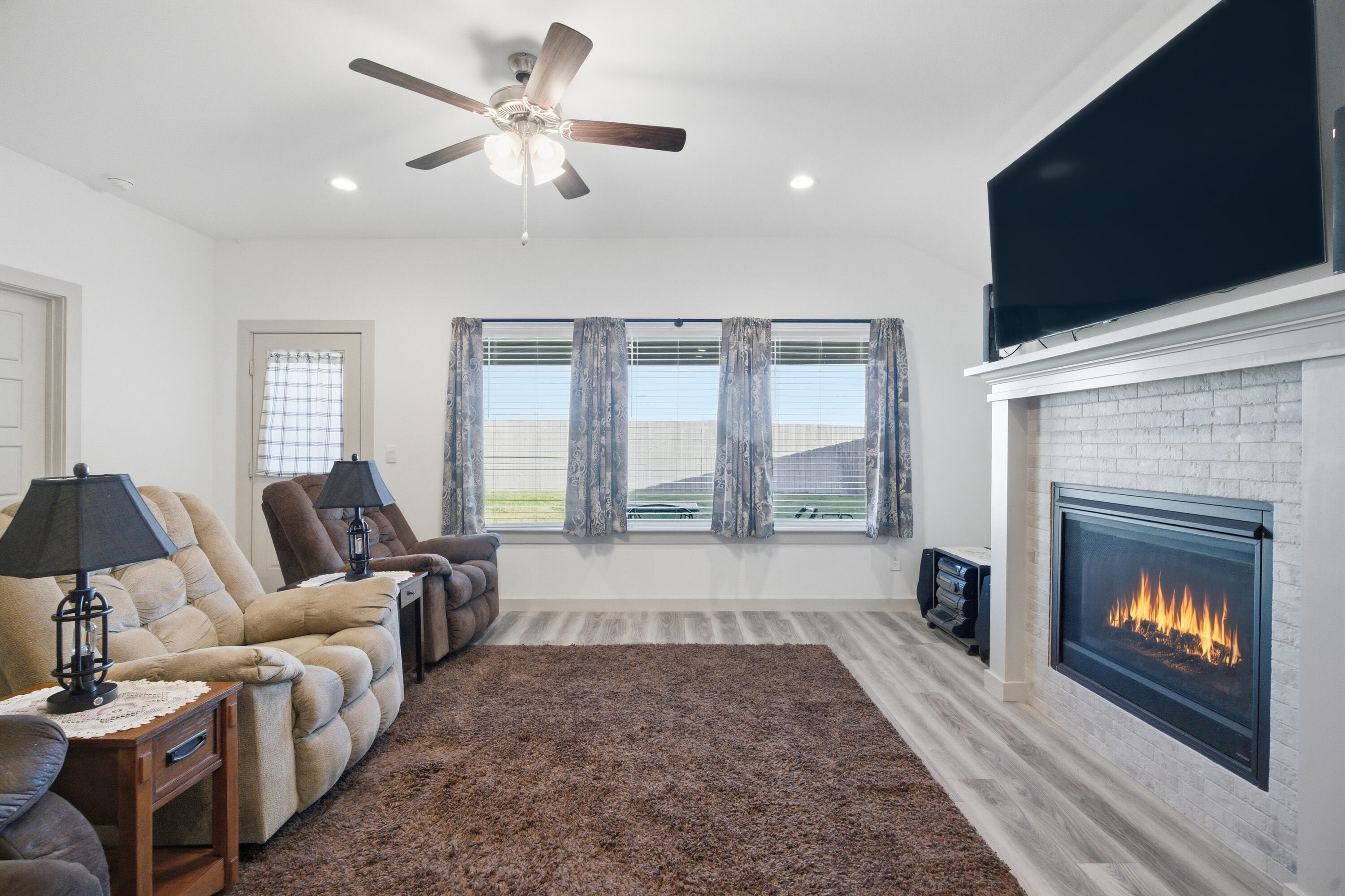 2902 133rd Street Lubbock, TX 79423 - Photo 7 of 38 a living room with furniture a fireplace and a flat screen tv