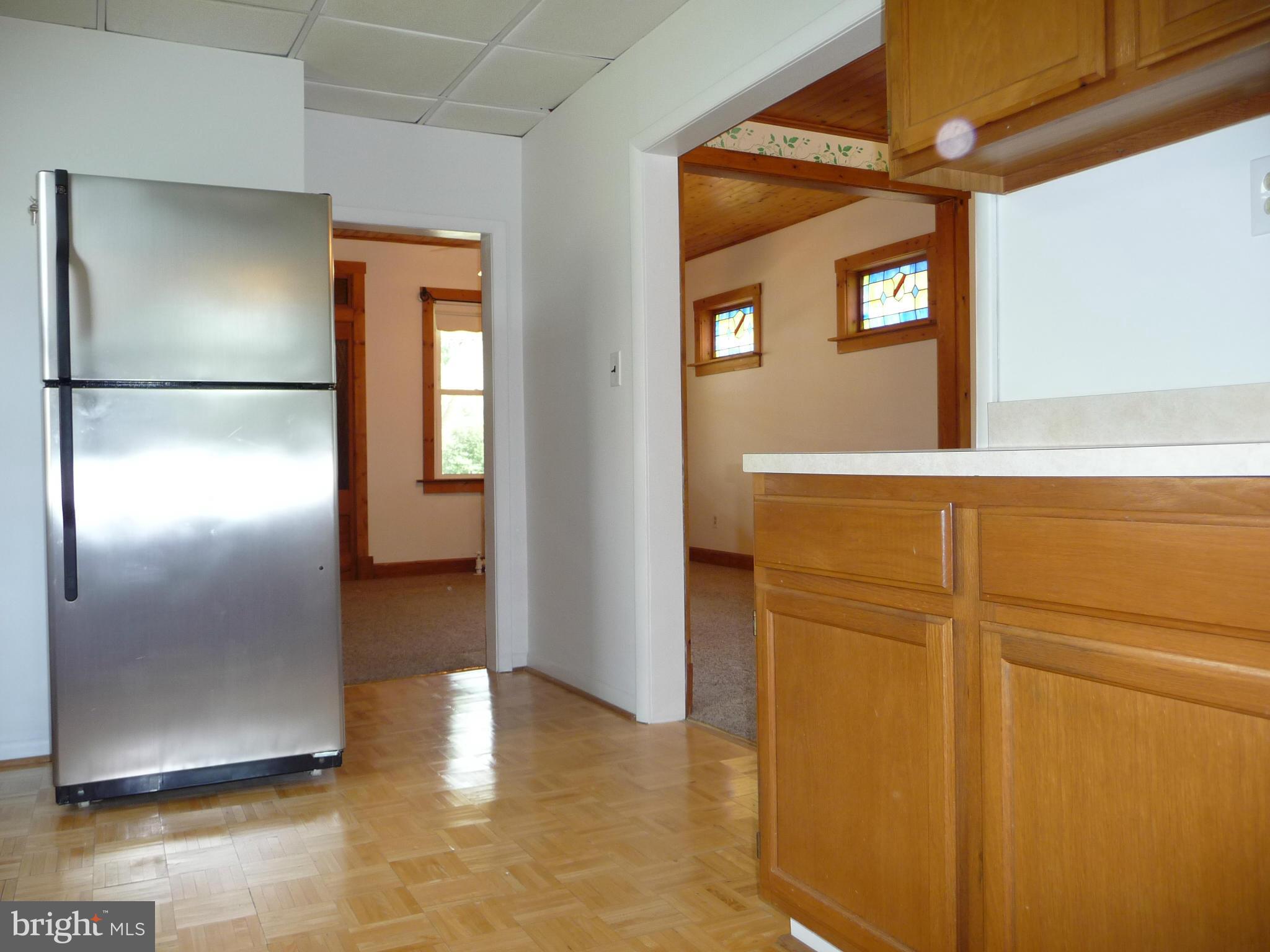 409 Walcott Road Baltimore, MD 21206 - Photo 2 of 27 a view of a livingroom with wooden floor and a kitchen