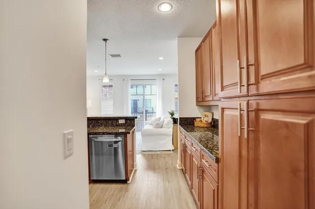 a kitchen with granite countertop a refrigerator and a sink