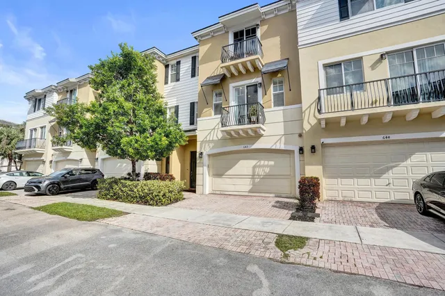 a front view of a building with a yard and parking space