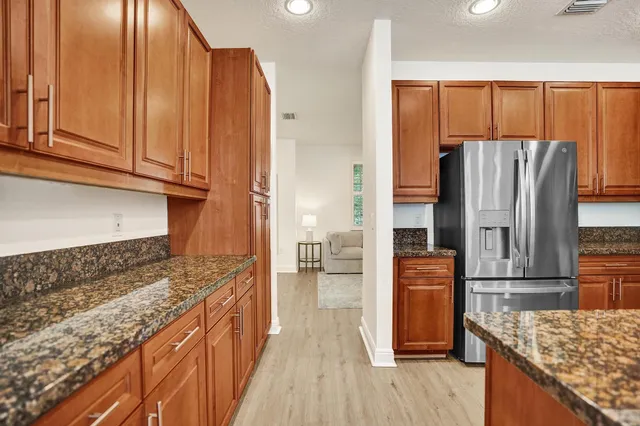 a kitchen with stainless steel appliances granite countertop a refrigerator a stove a sink and a microwave