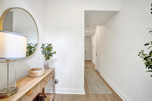 a view of a hallway with wooden floor and staircase