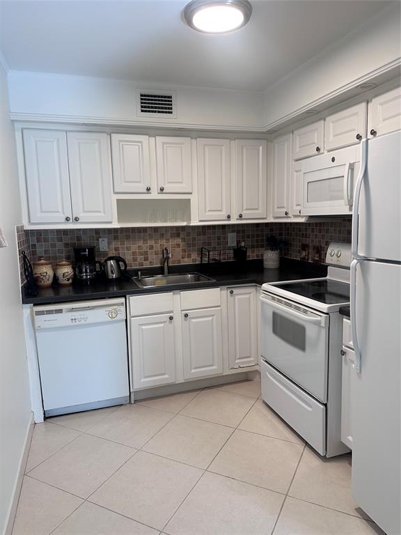 a kitchen with white cabinets and white appliances