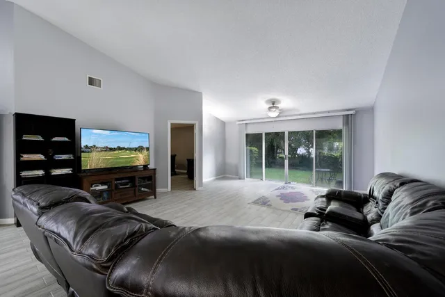 a living room with furniture a large window and a flat screen tv