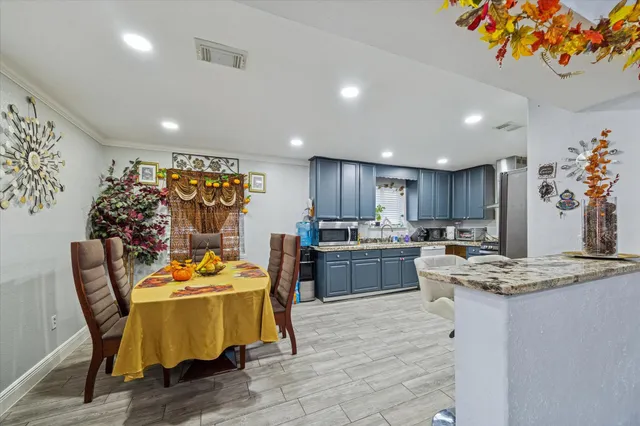 a dining room filled chandelier and wooden floor