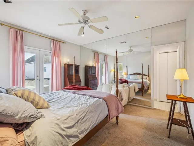 a bedroom with a bed mirror and a chair