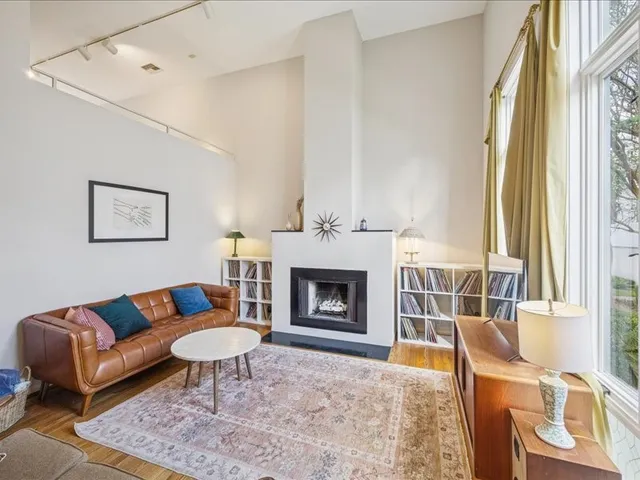 a living room with furniture a fireplace and a large window