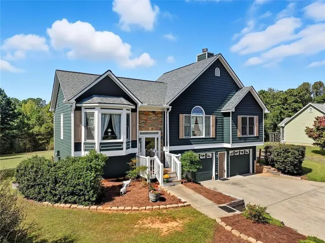 a view of a house with large windows and a yard