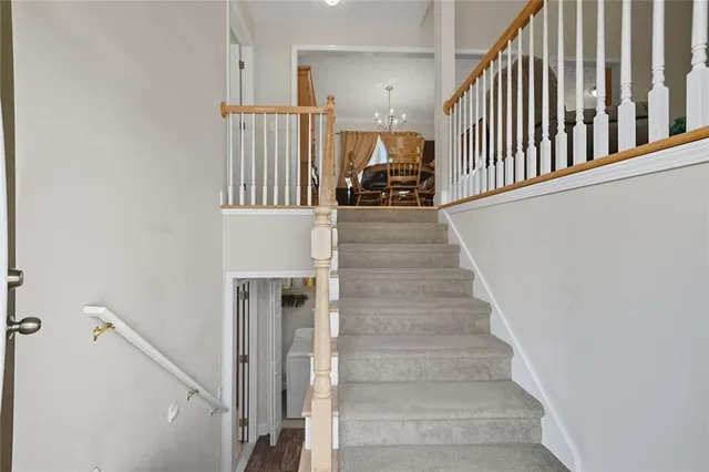 a view of staircase with lots of frames on wall and windows
