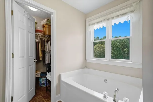 a bathroom with a tub a window and a shower