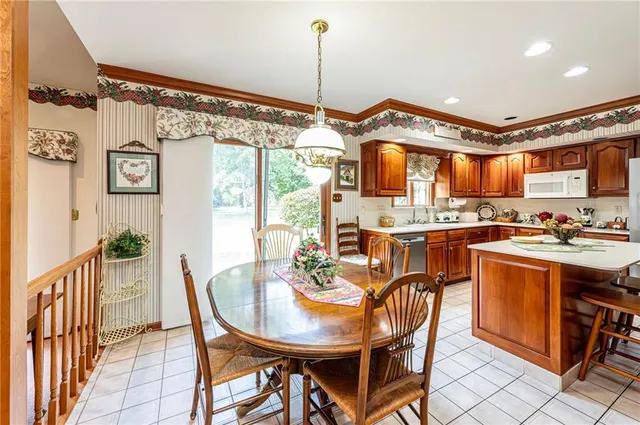 an empty room with a chandelier fan and windows
