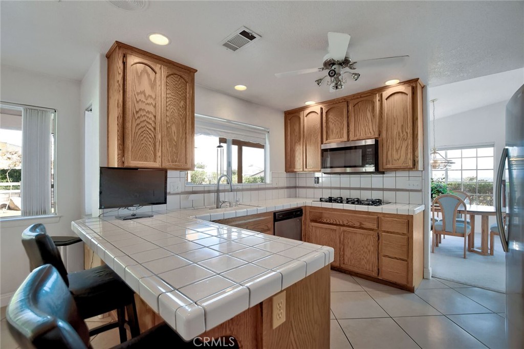 18032 Ohna Road Apple Valley, CA 92307 - Photo 16 of 65 a kitchen with stainless steel appliances granite countertop a stove refrigerator sink and cabinets