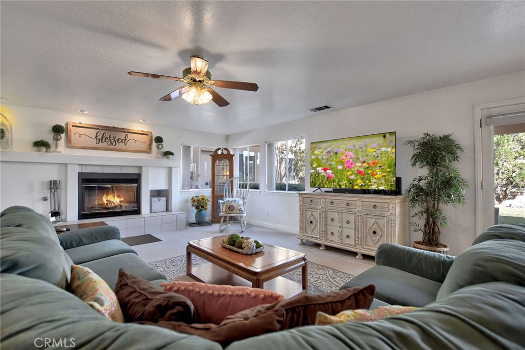 18032 Ohna Road Apple Valley, CA 92307 - Photo 22 of 65 a living room with furniture a flat screen tv and a fireplace