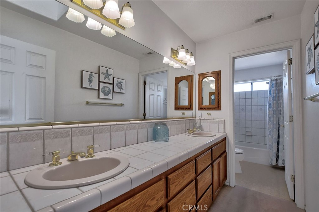 18032 Ohna Road Apple Valley, CA 92307 - Photo 42 of 65 a bathroom with a sink double vanity and a mirror