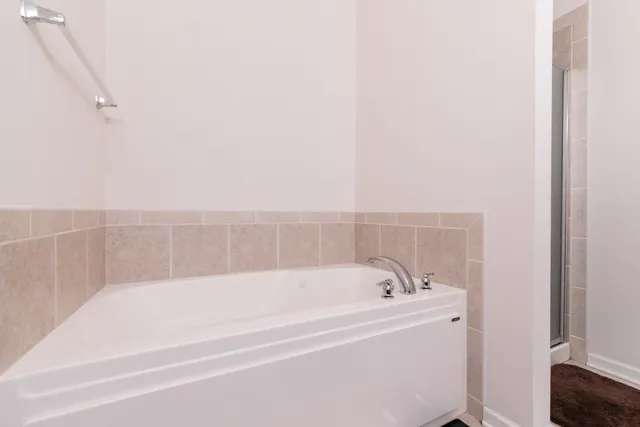 a spacious bathroom with bathtub and shower