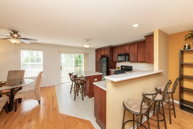 a kitchen with a table chairs a stove a dining table and chairs