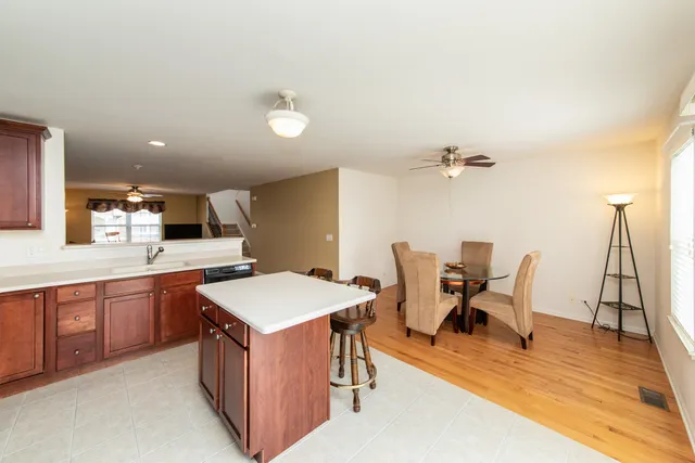 a kitchen with a sink chairs and wooden floor