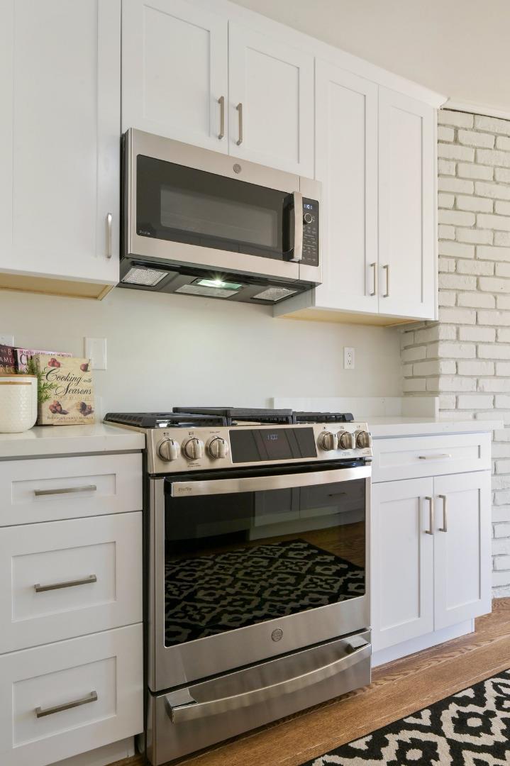 2135 Queens Lane San Mateo, CA 94402 - Photo 13 of 50 a kitchen with stainless steel appliances granite countertop a stove microwave and cabinets
