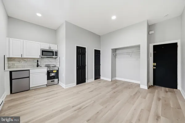 a view of kitchen with wooden floor and electronic appliances