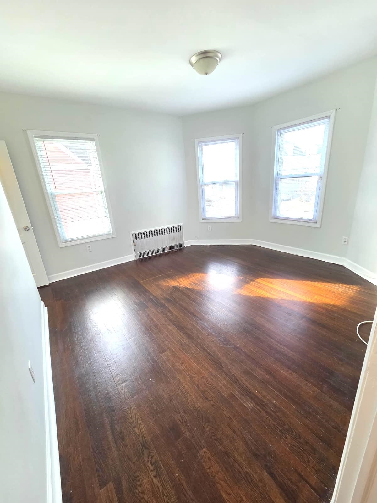 438 Devon Street, Unit 2 Kearny, NJ 07032 - Photo 2 of 27 an empty room with wooden floor and windows