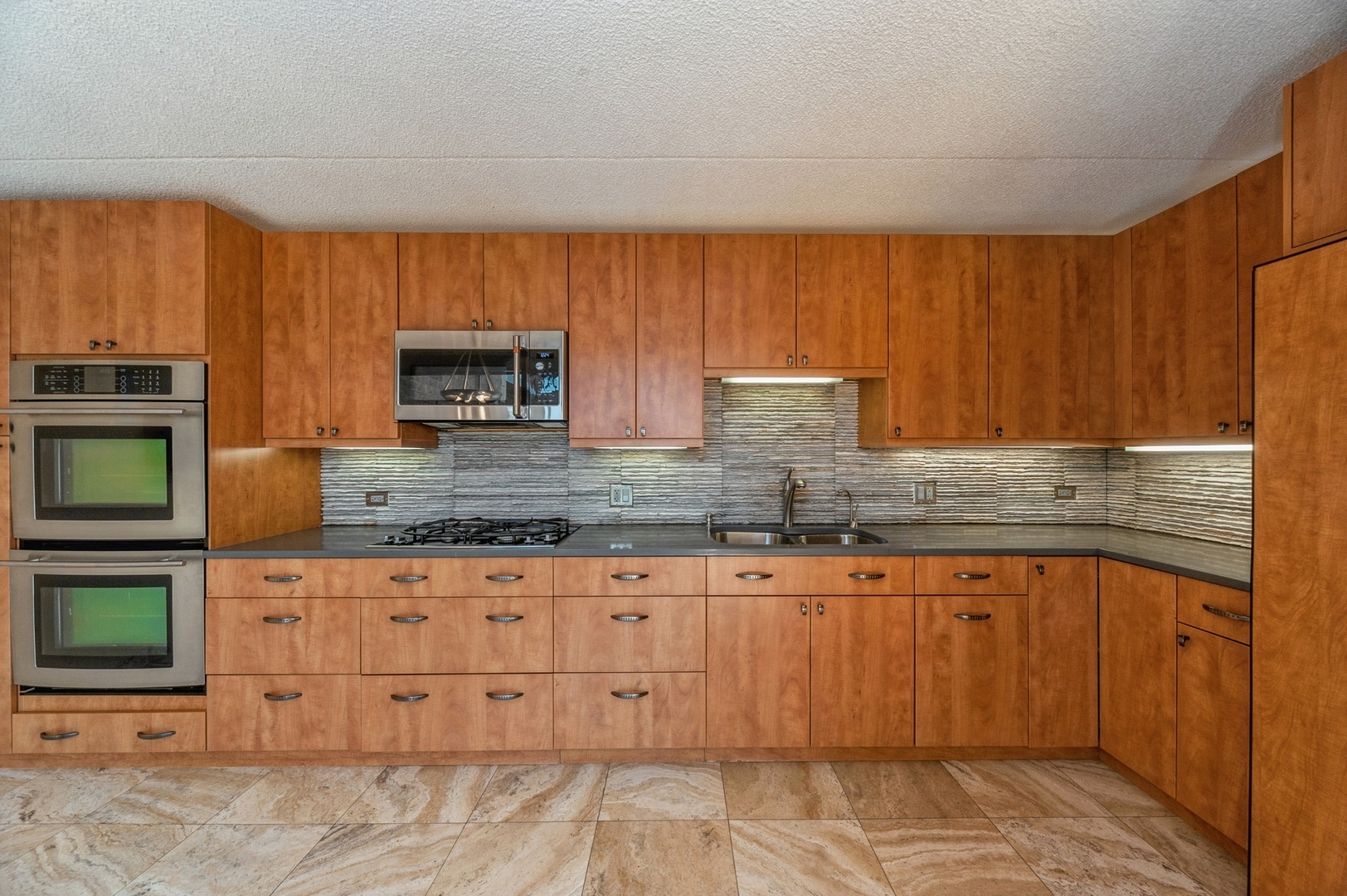 53 Avon Road Northbrook, IL 60062 - Photo 7 of 26 a kitchen with granite countertop a stove top oven microwave and cabinets