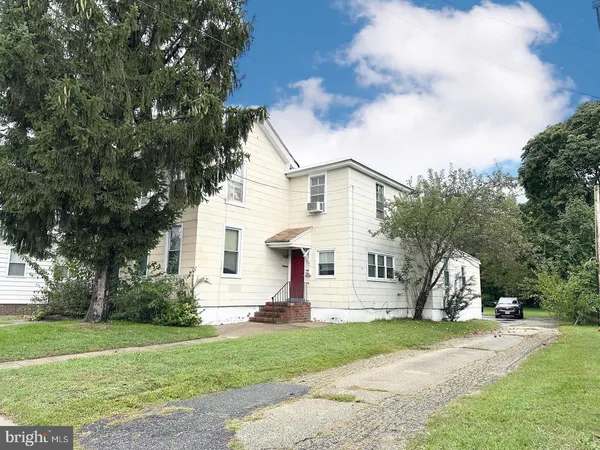 a view of a house with a yard and tree s
