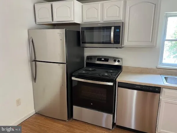 a kitchen with stainless steel appliances granite countertop a refrigerator stove and microwave