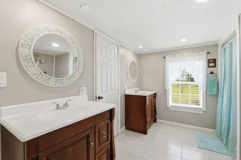 a bathroom with a sink mirror and a window