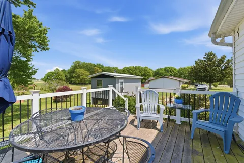a view of house with a deck and furniture