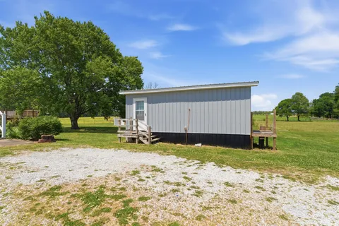 a view of a house with backyard and a tree