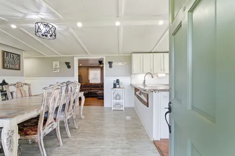 a kitchen with stainless steel appliances a table chairs and a refrigerator