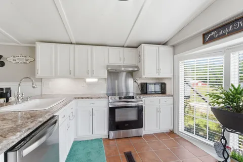 a kitchen with stainless steel appliances granite countertop a stove a sink and a refrigerator