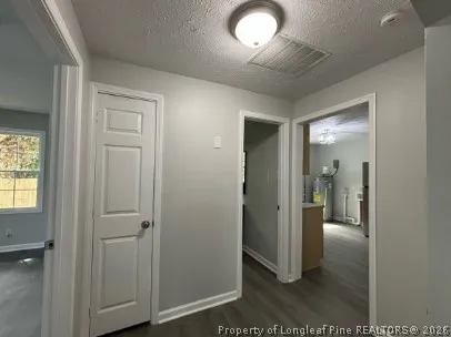 wooden view of a hallway with wooden floor and a livingroom