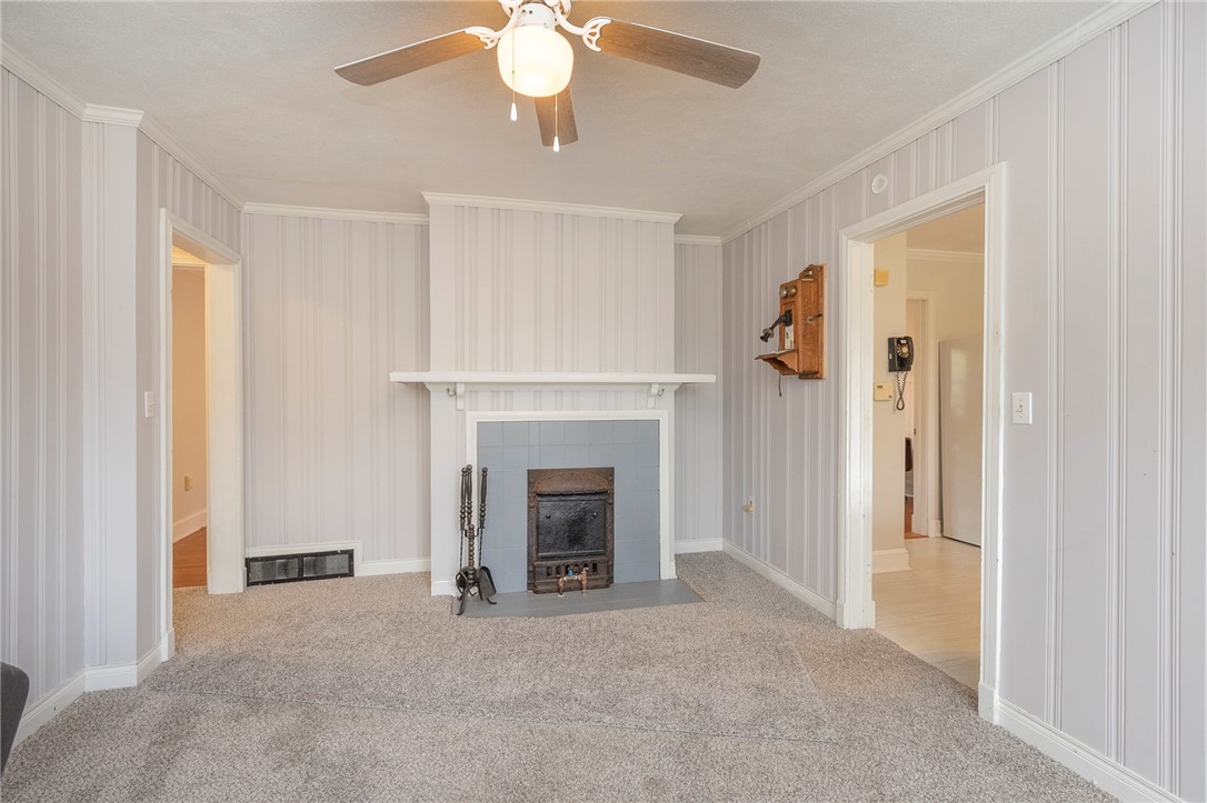 1218 Bolt Drive Anderson, SC 29621 - Photo 25 of 46 A comforting living space features a tiled fireplace, soft carpeting, and beadboard paneling.