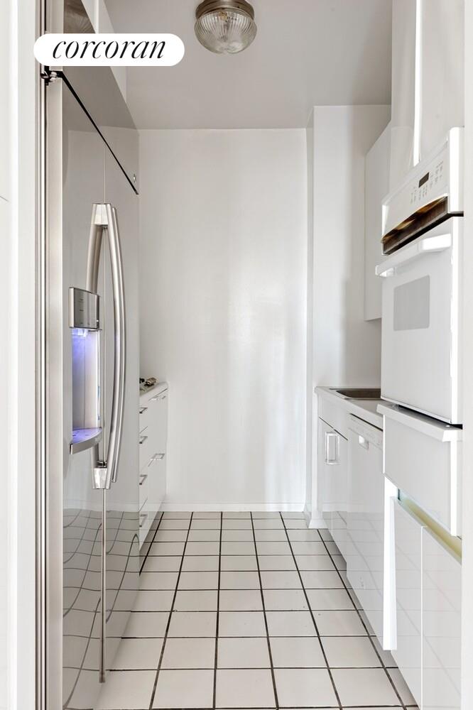 200 East 69th Street, Unit 21A Manhattan, NY 10021 - Photo 2 of 12 a view of a kitchen with white cabinets