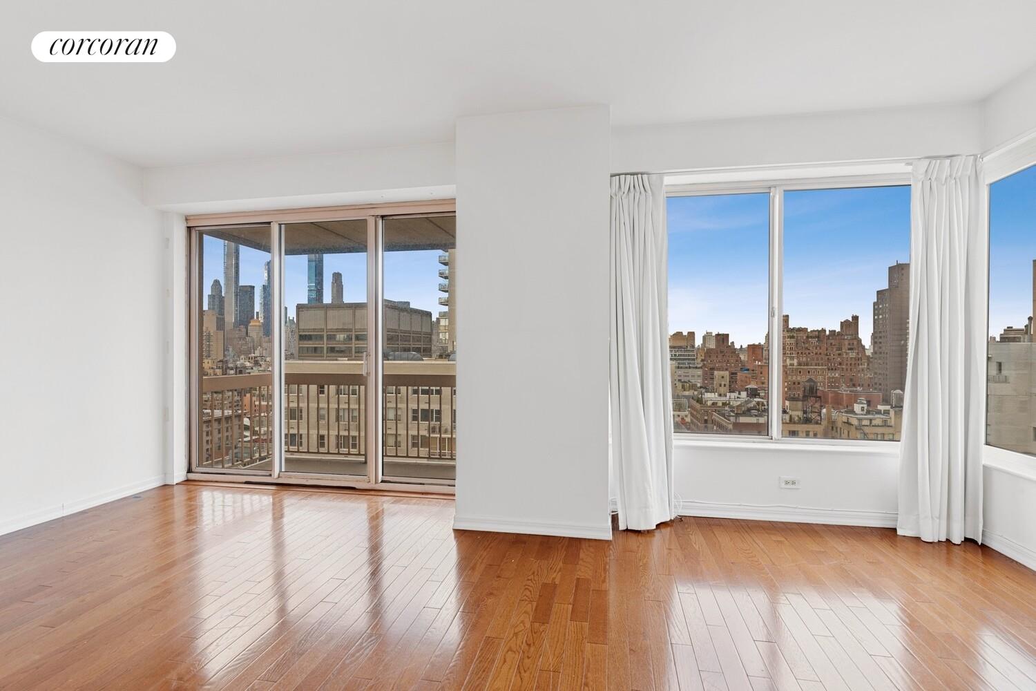 200 East 69th Street, Unit 21A Manhattan, NY 10021 - Photo 3 of 12 an empty room with wooden floor and windows
