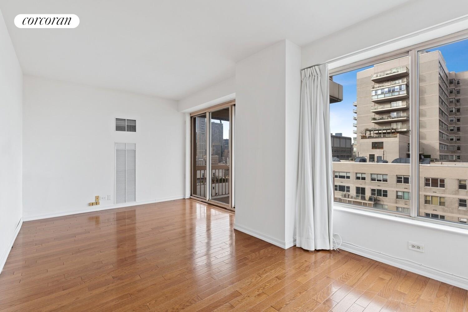 200 East 69th Street, Unit 21A Manhattan, NY 10021 - Photo 4 of 12 a view of an empty room with window and wooden floor